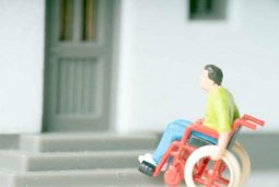 Symbolbild Rollstuhlfahrer vor Eingangstreppe